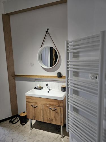 a bathroom with a sink and a mirror at BLACK BOX CINEMA appartement avec balnéo in Épinal