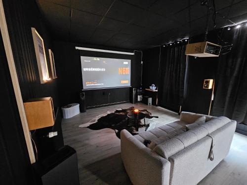 a living room with a couch and a projection screen at BLACK BOX CINEMA appartement avec balnéo in Épinal