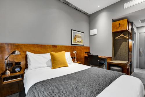a hotel room with a bed and a desk at King and Queen Hotel Suites in New Plymouth