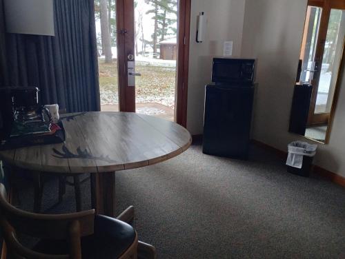 a room with a wooden table and a refrigerator at Centerstone Resort Lake-Aire in Tomahawk