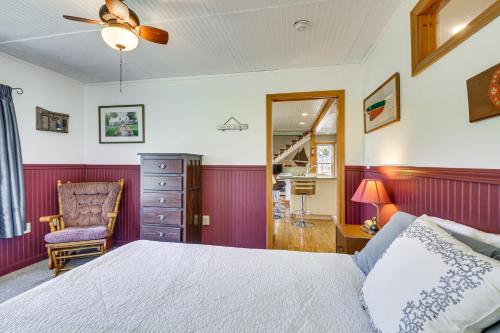 1 dormitorio con cama, silla y espejo en Historic Friendship Boat House Near Back River!, en Friendship
