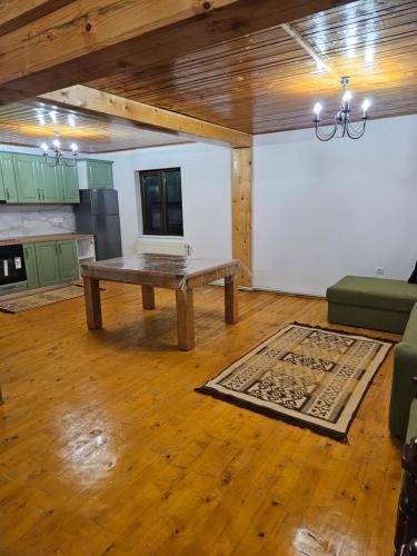 sala de estar con mesa de madera y cocina en Cabana Cezar, en Budureasa