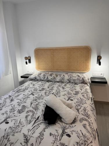a bed with a stuffed animal on top of it at Apartamento Maui beach en el palo in Málaga