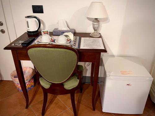 biurko z krzesłem i lampką oraz telefon w obiekcie B&B Giardino delle Camelie w mieście Capannori