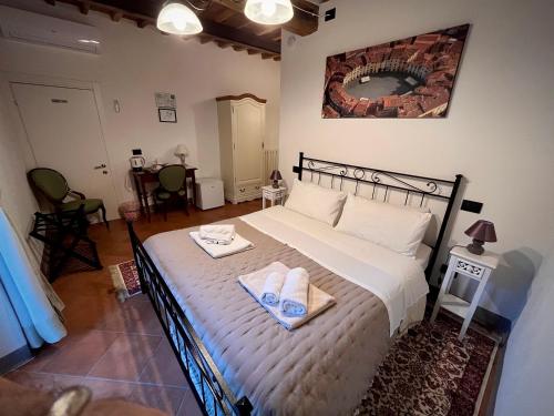 sypialnia z dużym łóżkiem z ręcznikami w obiekcie B&B Giardino delle Camelie w mieście Capannori