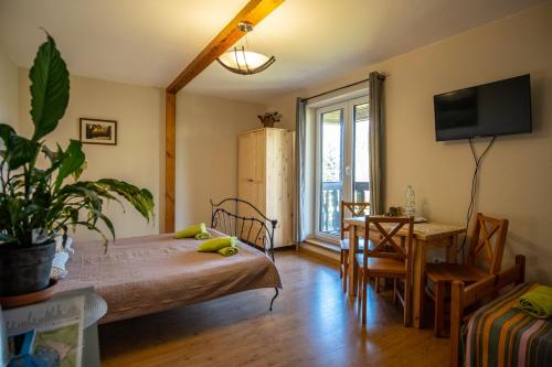 a bedroom with a bed and a table and a dining room at Siedlisko Leszczewek in Leszczewek
