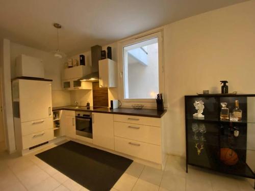 eine Küche mit einem weißen Kühlschrank und einem Fenster in der Unterkunft Schöne Wohnung in zentraler Lage in Klagenfurt am Wörthersee