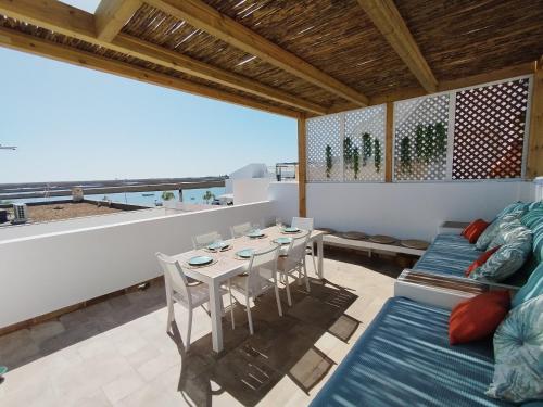 a room with a table and chairs and a view of the ocean at Living Luzia in Santa Luzia