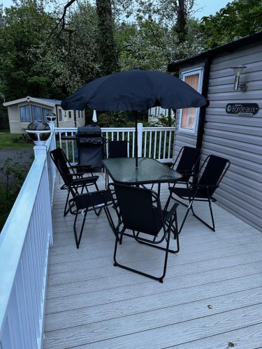 a table and chairs with an umbrella on a deck at Relax & Dream in Edinburgh