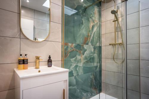 a bathroom with a shower with a sink and a mirror at Heather Nook- luxury studio in Pitlochry in Pitlochry