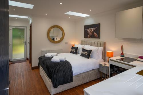 a bedroom with a large bed and a mirror at Heather Nook- luxury studio in Pitlochry in Pitlochry