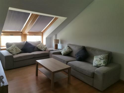 uma sala de estar com dois sofás e uma mesa de centro em PRECIOSO ATICO MONDARIZ em Mondariz