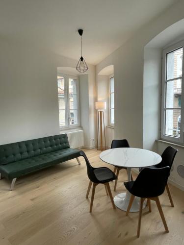 ein Wohnzimmer mit einem grünen Sofa und einem Tisch in der Unterkunft Le vie del vento - Garibaldi in Triest