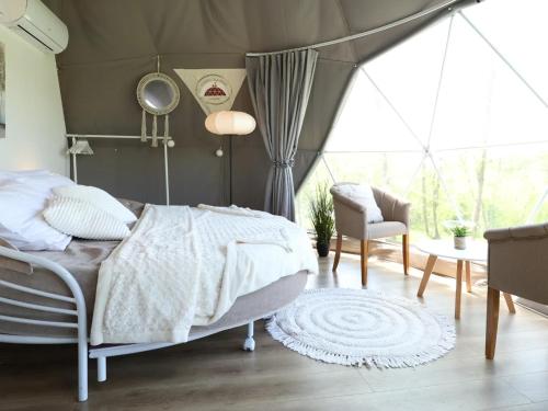 a bedroom with a bed and a chair and a table at Cherry Glamping Vranic in Vranić