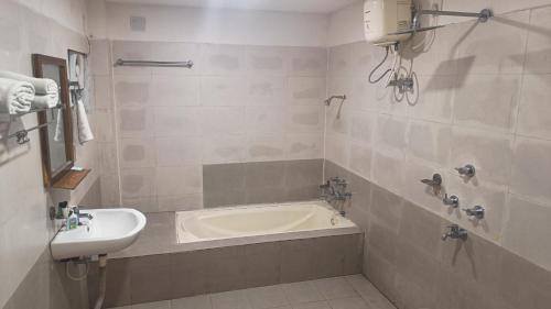 a bathroom with a bath tub and a sink at Wild Dunes Konark in Bālighāi