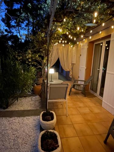 un patio con una mesa, un árbol y luces en Ô Coeur Des Ocres en Roussillon