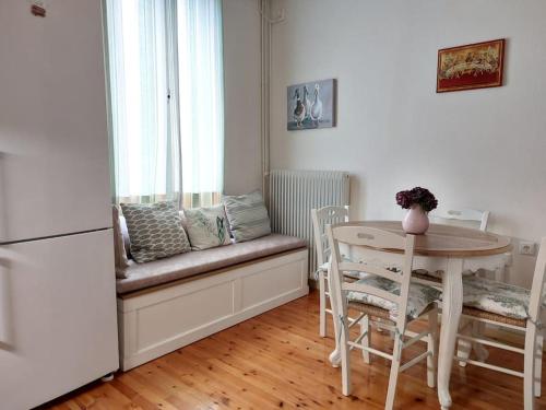 a kitchen with a bench with a table and a window at Happy House-Comfortable Apartment in Vathi Square in Meganisi