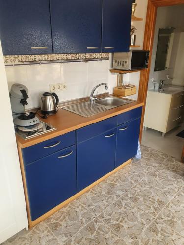 una cocina con armarios azules y fregadero en Casa pajarera, en Fortuna