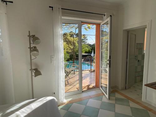 um quarto com uma porta de vidro deslizante para um deque em Ô Coeur Des Ocres em Roussillon