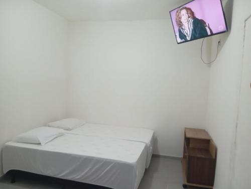 a room with two beds and a tv on the wall at FLAT - primeiro andar - perto do Classic Hall e Centro de Convenções in Recife