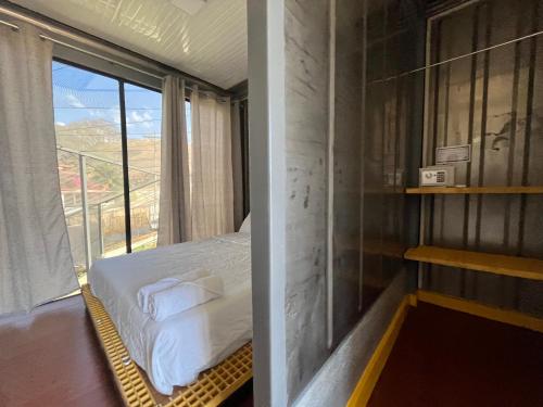 a bedroom with a bed and a large window at Pupa House in Tamarindo