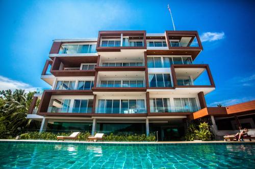 a building with a swimming pool in front of it at Q Kata Residence in Kata Beach
