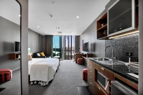 a hotel room with a bed and a sink at King and Queen Hotel Suites in New Plymouth