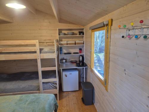 にあるLonni camping in natureの二段ベッド1組、冷蔵庫が備わる小さな客室です。