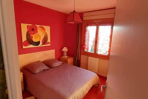 - une chambre rouge avec un lit et une fenêtre dans l'établissement un amour de maison, au Conquet