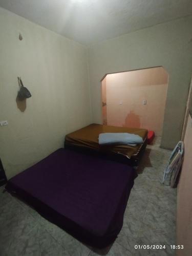 a small room with a bed and a door at Hostel parque ecológico in Juazeiro do Norte