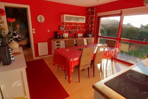 une cuisine rouge avec une table et des chaises rouges dans l'établissement un amour de maison, au Conquet