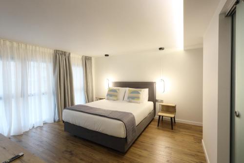 une chambre avec un grand lit et une fenêtre dans l'établissement ZEN STUDIO, à Ioannina