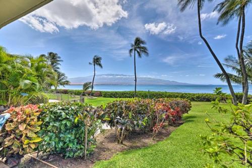 a garden with palm trees and a view of the ocean at Stunning Maui Direct Ocean front on the beach, Walk to beach from Condo, Watch Turtles, Whales, AC in all rooms ocean view Pool and Spa in Wailuku