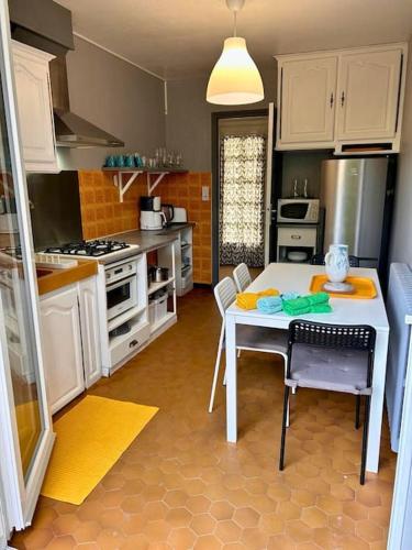 une cuisine avec une table et une cuisinière four supérieur dans l'établissement Maison Médicis - T5 Spacieuse et Calme en Ville - Emplacement Idéal, à Toulouse