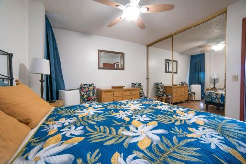 1 dormitorio con 1 cama grande con manta azul y blanca en Stunning Maui Ocean front Walk to beach Watch Turtles Whales AC in all rooms Pool Spa, en Wailuku