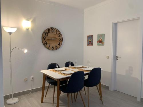 uma sala de jantar com uma mesa e um relógio na parede em Happydreams apartment in Albufeira em Albufeira