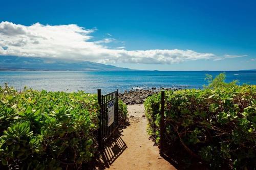 a path leading to a beach with the ocean at Stunning Maui Direct Ocean front on the beach, Walk to beach from Condo, Watch Turtles, Whales, AC in all rooms ocean view Pool and Spa in Wailuku