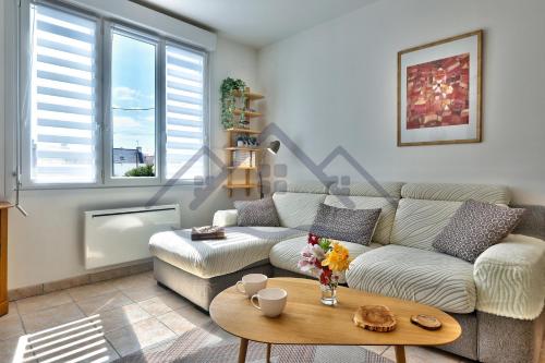 a living room with a couch and a table at LocaLise - M2C - Ty Ma Bro -Maison avec extérieur entièrement clos - Wifi inclus - Draps inclus- Animaux bienvenus in Le Guilvinec