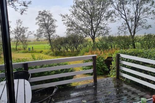 a porch with a bench and a view of a field at Lovely retro cabin close to Geysir and Gullfoss in Selfoss