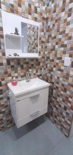een badkamer met een wastafel en een spiegel bij Beth acomodações in Laguna