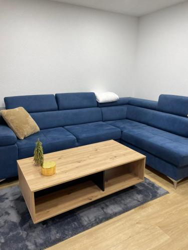 a blue couch in a living room with a coffee table at Vila Flora Vlašić in Šišava