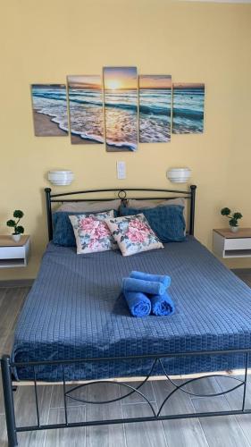 a bed in a bedroom with four paintings on the wall at Giovanni Apartments Kos Studio 20 in Kos