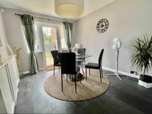 a dining room with a table and black chairs at Serenity Haven in Hackbridge
