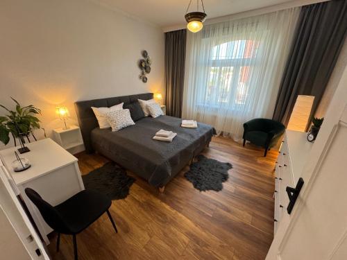 a small bedroom with a bed and a table and chairs at Apartament ALMAR Cieplice-Zdrój in Jelenia Góra
