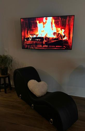 a chair with a heart sitting in front of a fireplace at The Moon Chambre romantique proche de Nancy in Bouxières-aux-Dames