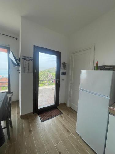 a kitchen with a refrigerator and an open door at DOMO A MARE in Magomadas