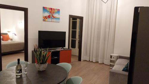 a living room with a table and a television at Napoli Mariana Luxury in Naples