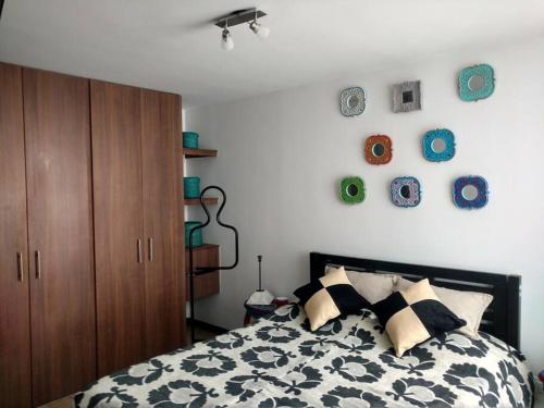 1 dormitorio con 1 cama y algunos platos en la pared en Cómodo apartamento en Tocancipa, en Tocancipá