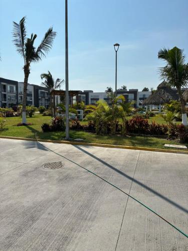 an empty street with palm trees and a building at Departamento Boutique con más Amenidades que Ningún otro en la Zona in Acapulco