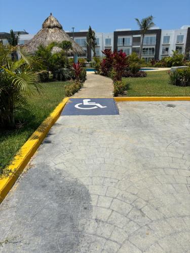 a handicapped parking sign on a sidewalk in front of a building at Departamento Boutique con más Amenidades que Ningún otro en la Zona in Acapulco